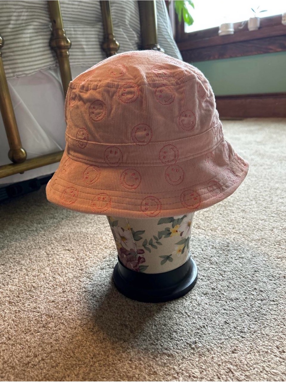 American Eagle Outfitters pink bucket hat with repeating smiley face embroidery